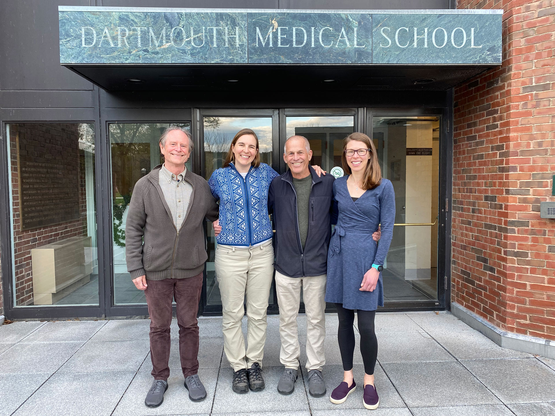 Four people in front of Dartmouth Medical School